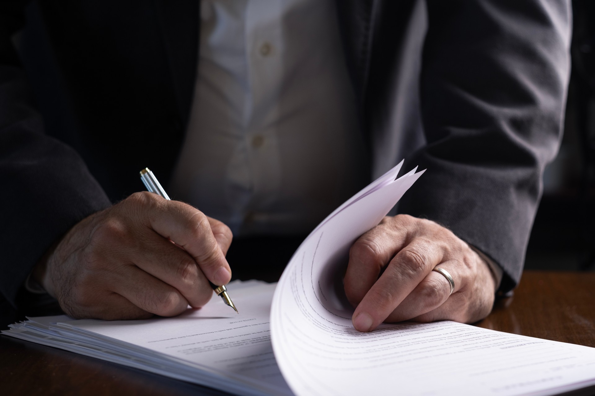 unknown businessman examining and signing documents